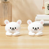 Two white cartoon bear desk cable organizers sitting on a wooden surface.