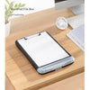 A black writing board file box with a clip and pen slot placed on a wooden desk.