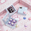 A collection of pink and purple cat paw and heart keycaps for MX switches displayed on a pink background.