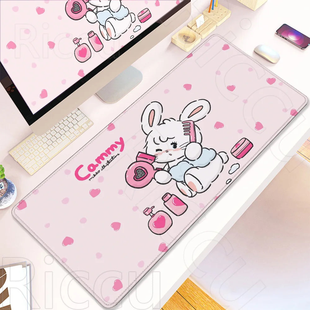 A pink cartoon gaming desk mat featuring a white rabbit illustration and pink accessories.