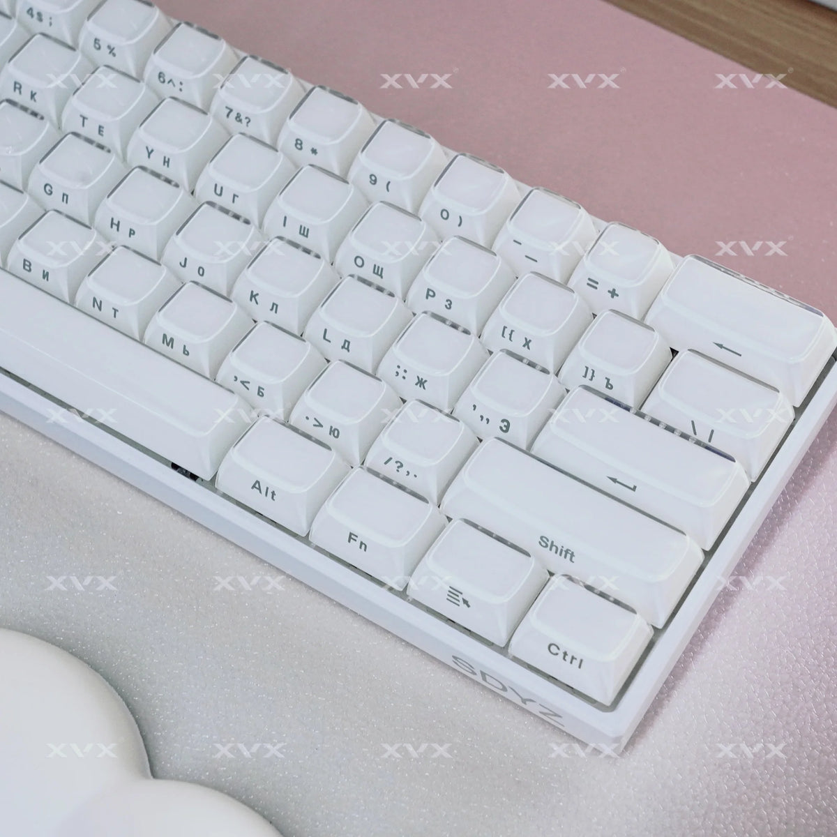 A close-up view of a white mechanical keyboard with translucent keycaps resting on a pink surface.