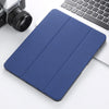 A dark blue retro marbling skin for an iPad Pro placed next to a silver camera and a white laptop keyboard.