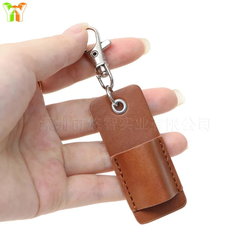 A hand is holding a brown leather pen holder keychain with a silver clasp.