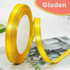 A roll of yellow satin ribbon with a gold edge is shown against a blurred background.