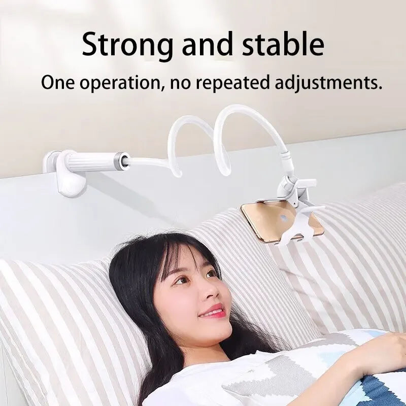 A woman is using a flexible gooseneck phone clamp mount attached to a bed for hands-free operation.