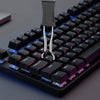 Vista cercana de un teclado mecánico negro con una herramienta para extraer teclas insertada en una tecla.