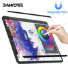 Eine Hand schreibt auf einem Tablet-Bildschirm, geschützt durch eine magnetische Folie, mit leuchtenden Farben.