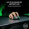 A hand is holding a black Razer Viper V3 Pro wireless gaming mouse on a dark surface with green lighting in the background.