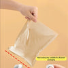A hand is using a handheld heat sealing tool to seal a plastic bag for food preservation.