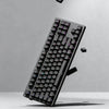 A close-up, angled view of a black mechanical keyboard featuring PBT double-shot cherry profile keycaps.