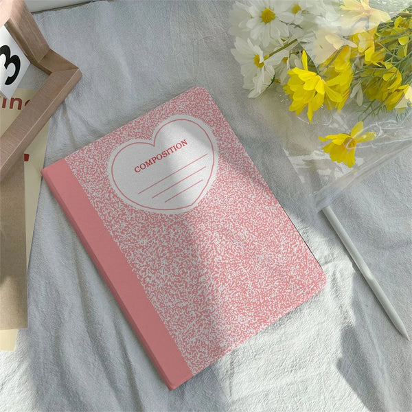 Rosa Notizbuchcover mit Herzdesign und Bleistiftehalter auf weißem Tuch