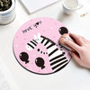 A pink round mouse pad featuring a black and white zebra design and the text I love you