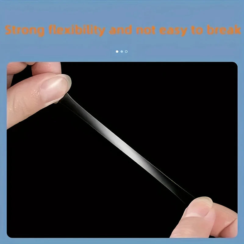 A hand is demonstrating a thin, black flexible strip of transparent double-sided mounting tape.