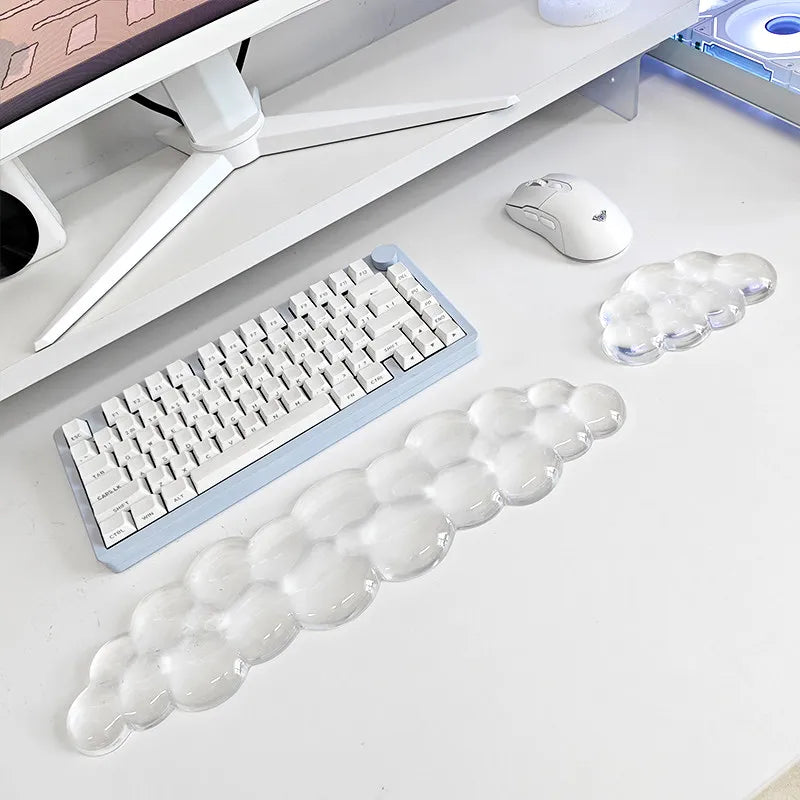 A clear, elongated cloud wrist rest for keyboard and mouse placed next to a white computer keyboard and mouse.