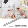 A hand uses a stainless steel ruler to measure on an engineering blueprint.