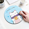 A cute illustration of a white cat with purple stripes and a yellow heart on a light blue mouse pad for a desk.