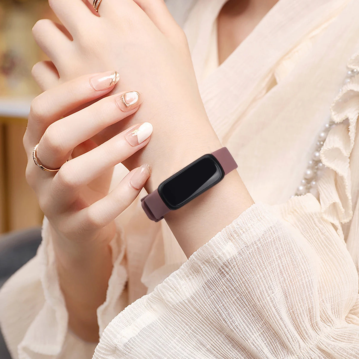 A woman is wearing a silicone replacement strap for a Fitbit Inspire Series on her wrist.