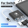 A black 3-in-1 multifunctional docking station with a white cable shown next to a Nintendo Switch console.