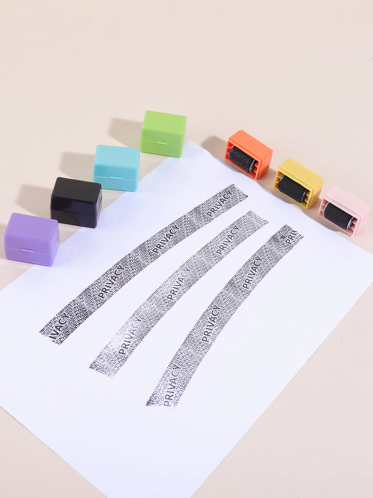A collection of colorful privacy protection roller stamps arranged diagonally on a white sheet of paper.