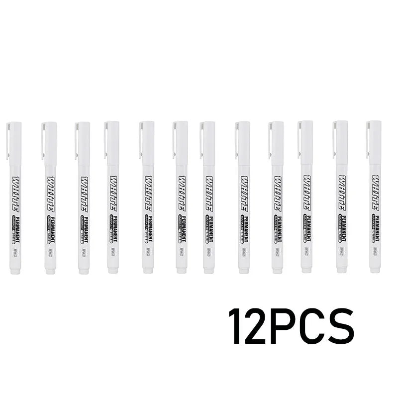 A set of twelve white metal paint markers displayed in a row.