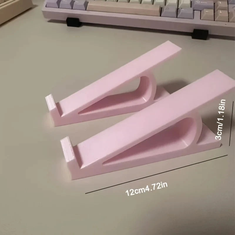 Pinker ergonomischer Tastenhörner, der die Höhe einer Tastatur erhöht, auf einem Schreibtisch neben einer Tastatur.
