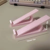Pinker ergonomischer Tastenhörner zur Höhenanpassung auf einem Schreibtisch neben einer Tastatur