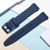 A dark blue silicone watch strap is shown alongside replacement tools on a light background.