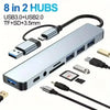 A silver docking adapter featuring 8 in 2 hubs, including USB3.0, USB2.0, TF, SD, and 3.5mm connectors.
