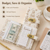 A beige notebook organizer with a leather strap holds cash, budget sheets, and a portable daily planner.