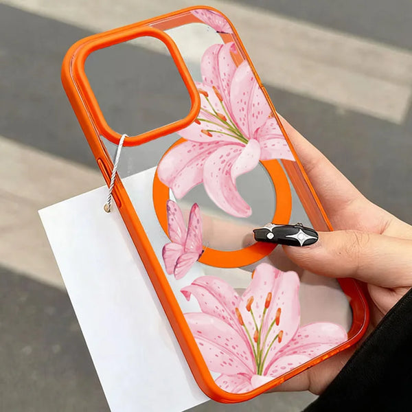 A hand holds a transparent orange iPhone case featuring a pink lily floral design.