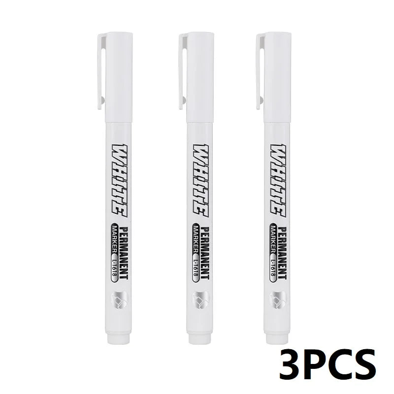 Three white permanent waterproof metal paint markers standing vertically.