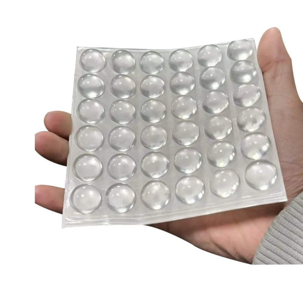 A hand holds a clear silicone sheet with numerous round stickers for long nails.