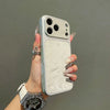 A hand holds a phone case with a frosted velvet texture and shockproof protection against a gray background.