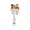 A cute brown hamster with pink bow eyes is attached to an acrylic badge reel.