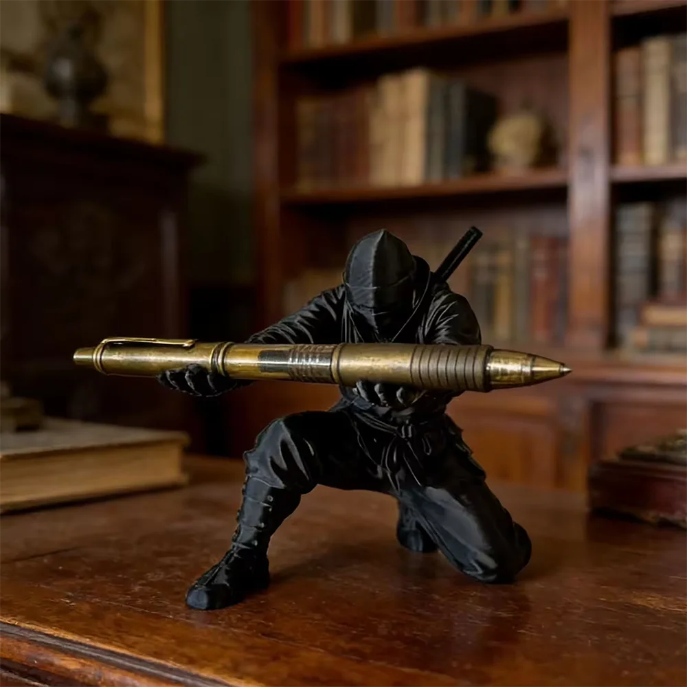 A matte black ninja figurine holding a gold pen, displayed on a wooden surface with bookshelves in the background.
