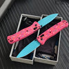 Pink donut acrylic folding knife with a blue steel blade displayed in a box.