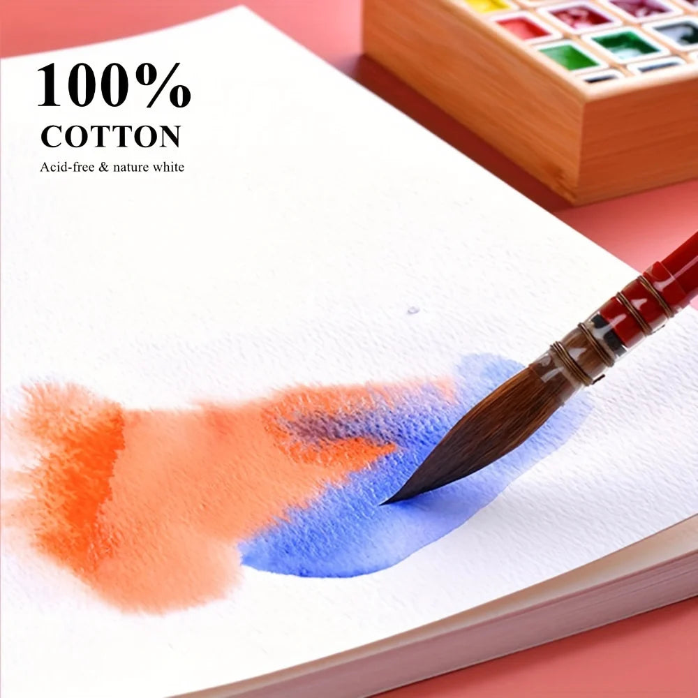 A watercolor painting featuring orange and blue washes on white paper, demonstrated with a paintbrush.