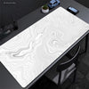 Extra large abstract desk mat with swirling white and gray patterns on a dark surface.