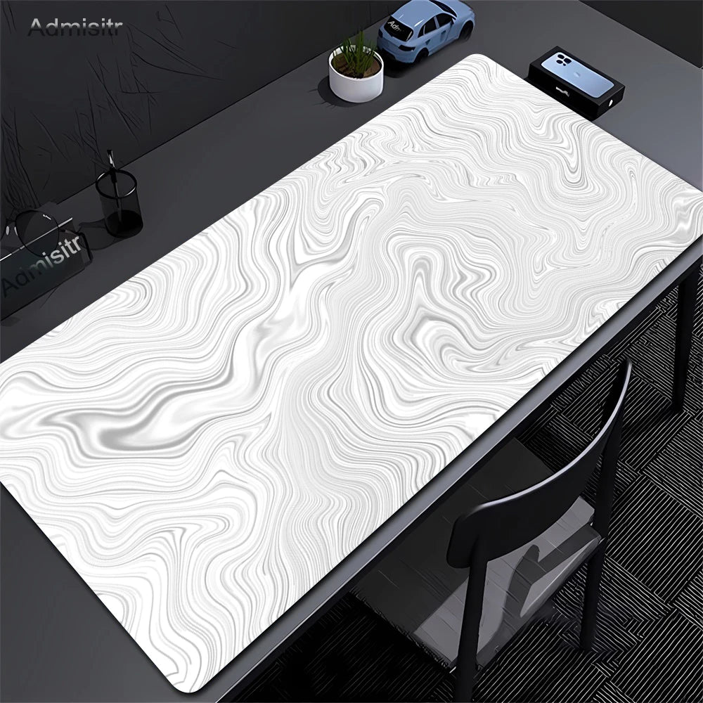 Extra large abstract desk mat with swirling white and gray patterns on a dark surface.