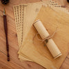 A stack of vintage European style letter and invitation envelopes made of light brown paper, with a rolled scroll tied with t