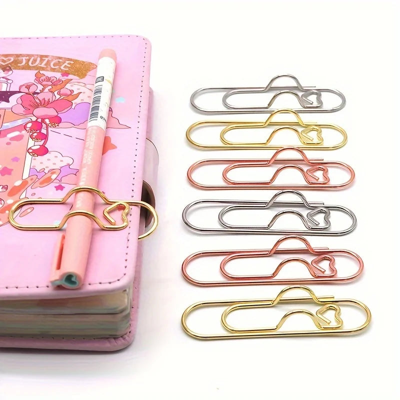 A collection of mixed color heart-shaped metal pen clips arranged in a vertical row.