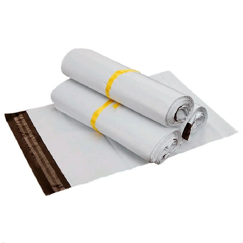 Rolls of white self-sealing plastic mailing bags tied with yellow string