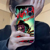 A hand holds a black iPhone case featuring a graphic of Michael Myers on an Elm Street background.