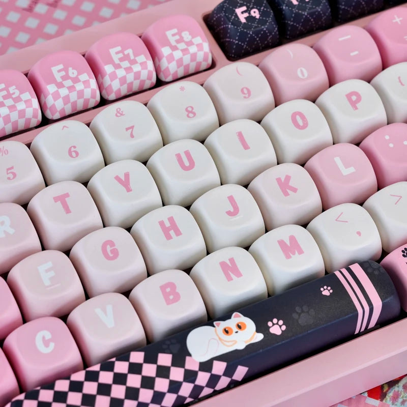 A pink and black cat print PBT keycap set for mechanical keyboards displayed in a plastic tray.