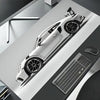 A white sports car model is displayed on a dark surface next to a gaming mousepad.