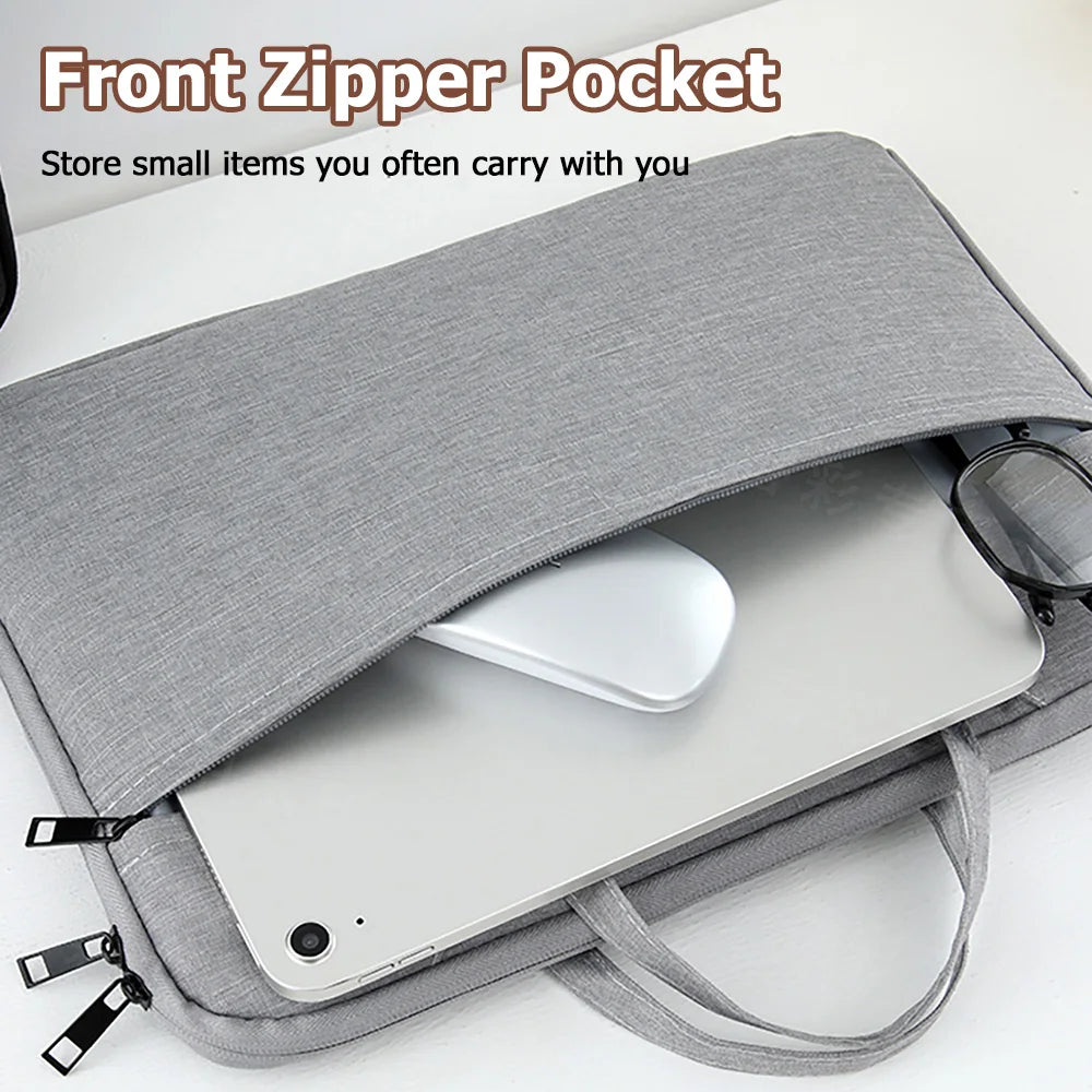 A gray front zipper pocket laptop sleeve holding a silver tablet or laptop.