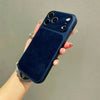 A hand holds a dark blue frosted velvet texture phone case with gold accents and multiple camera lenses.