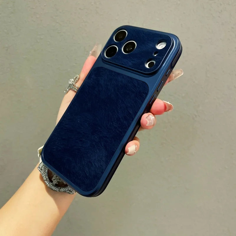 A hand holds a dark blue frosted velvet texture phone case with gold accents and multiple camera lenses.