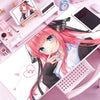 A close-up of an anime-style illustration featuring a pink-haired girl, surrounded by various stationery and tech accessories