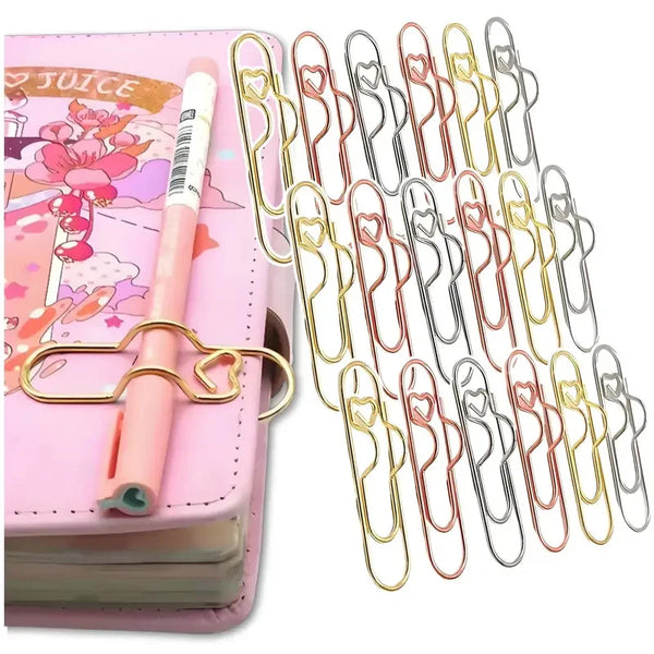 A set of elegant gold-colored metal pen clips designed for holding notebooks and journals.